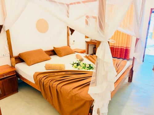 a bedroom with a bed with a mosquito net at Arugam Bay Resort in Arugam Bay