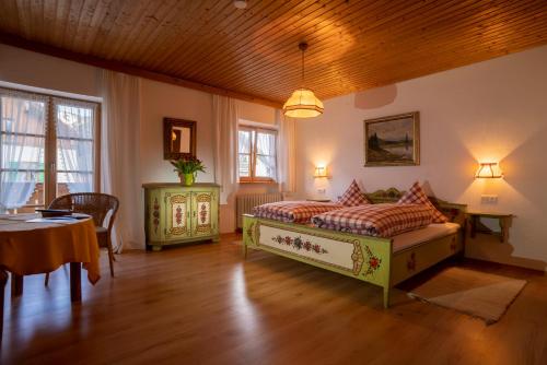 a bedroom with a bed and a table and chairs at Gästehaus Heiß in Lenggries