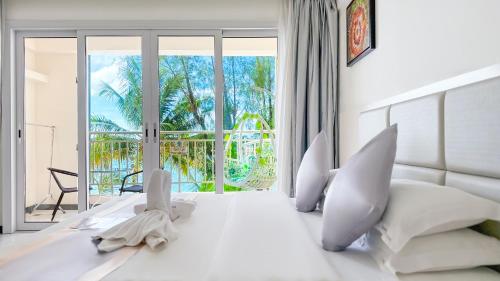a bedroom with a white bed with a large window at Ocean Star Hotel in Koror