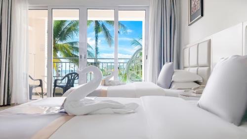 a white bedroom with swans on the bed at Ocean Star Hotel in Koror
