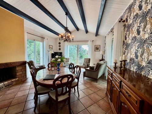 a dining room with a table and a fireplace at Les Fleurs De Lys, Villa Chic L'enclos Des Lys, Proche de la Mer in Saint-Georges-dʼOléron