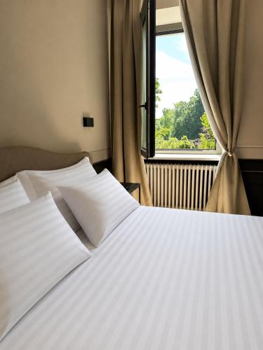 a bedroom with a white bed and a window at L'Orangerie del Castello in Morozzo