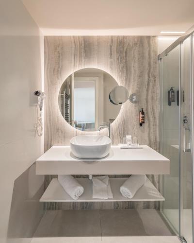a bathroom with a sink and a mirror at Les Dunes Comodoro in Benidorm