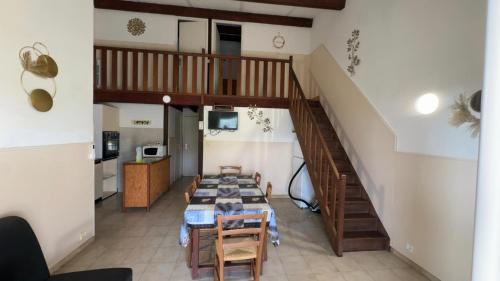 a living room with a table and a staircase at Sarl Aurore-Vacances in Vico