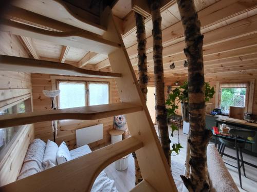a tree house with a view of a living room at Le chalet caché, au pied des Chambarans in Saint-Siméon-de-Bressieux