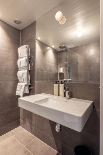 a bathroom with a white sink and a mirror at Gullmarsstrand Hotell & Konferens in Fiskebäckskil