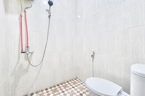a bathroom with a shower with a toilet at Urbanview Hotel MD Residence in Sunggal