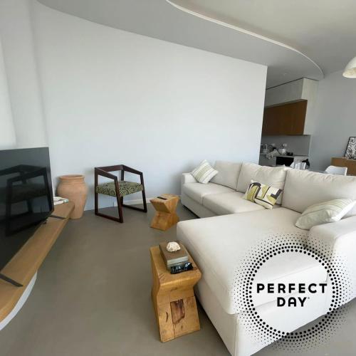 a living room with a white couch and a tv at Perfect Day Luxury Residences in Palasë