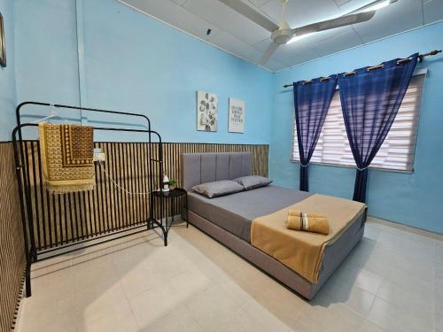 a bedroom with a bed in a blue room at Homestay Iliana in Kangar