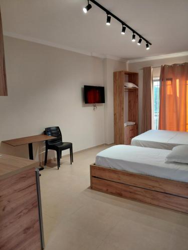 a bedroom with a bed and a desk and a television at Sol Apartments in Durrës