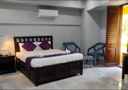 a bedroom with a large bed with purple pillows at Villa Victor in Pondicherry