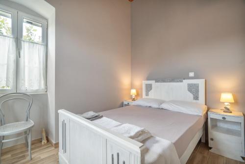 a white bedroom with a white bed and a chair at Traditional House in Rífion