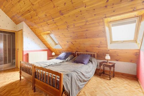 a bedroom with two beds in a wooden house at Gîte Le Panorama in Rentières
