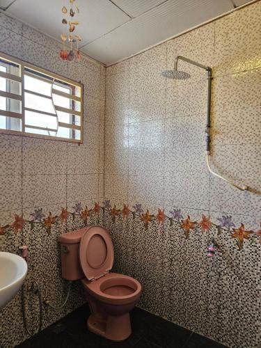 a bathroom with a toilet and a sink and a shower at Homestay Iliana in Kangar