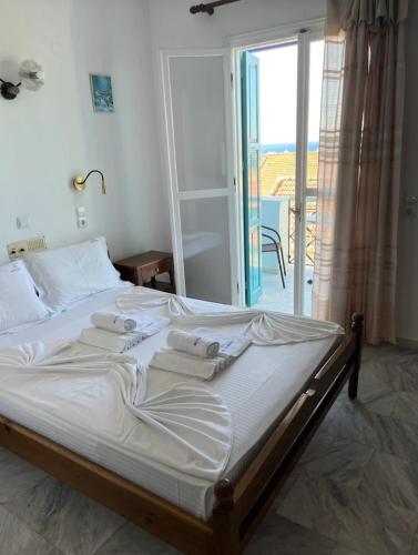 a bedroom with a bed with towels on it at Zorbas Hotel in Pythagoreio