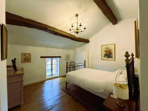 a bedroom with a bed and a chandelier at Maison Chinsa in Saint-Angeau