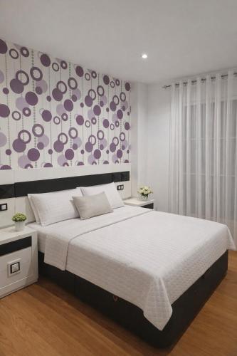 a bedroom with a large white bed and a wall at Casa Nankurunaisa in Vejer de la Frontera