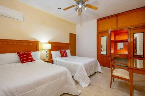 a bedroom with two beds and a ceiling fan at Amplia Habitación Doble 7, Alberca, Gym y Terraza in Mérida