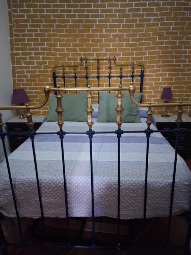 a bed in a room next to a brick wall at Casa rural las conchas in Cazalla de la Sierra