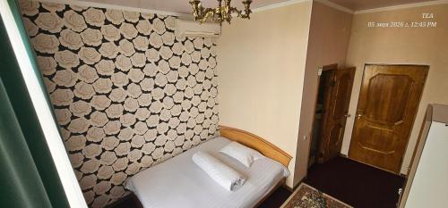 a small bedroom with a bed with a wall with at Corps Rose Velley in Almaty