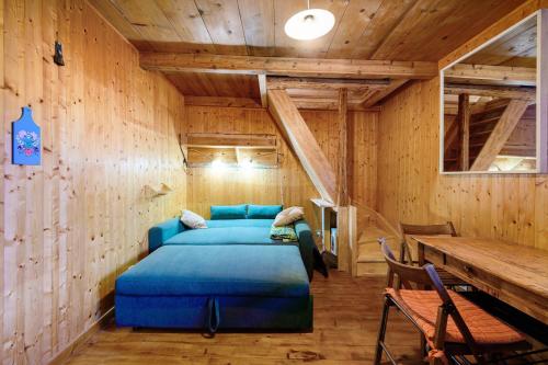 a bedroom with a blue bed in a wooden room at Petit chalet Chez Gaston in Saint-François-Longchamp