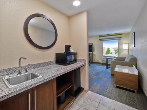 a hotel room with a sink and a living room at Hampton Inn Omaha Midtown-Aksarben in Omaha