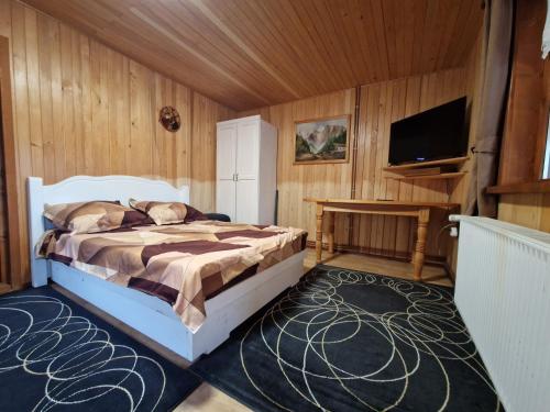 ein Schlafzimmer mit Bett und Flachbildfernseher in der Unterkunft Deer Chalet in Holda