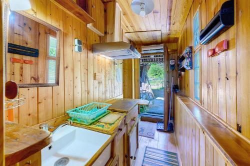 a kitchen with wooden walls and a sink and a counter at Petit chalet Chez Gaston in Saint-François-Longchamp