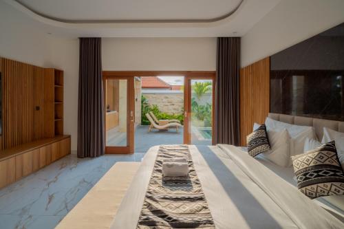 a large bedroom with a large bed and a patio at Suralaya Villas in Ubud