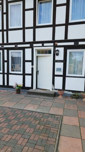 a black and white building with a white door at Monteurzimmer Ehmen in Wolfsburg