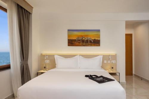 a bedroom with a white bed and a window at Tulip Residences Vipingo Mombasa in Mombasa