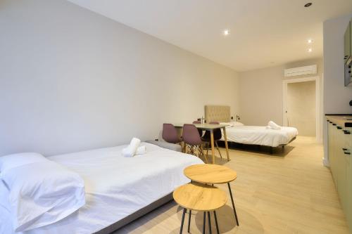 a bedroom with two beds and a table and chairs at Rosario 32 by keyhom in Salamanca