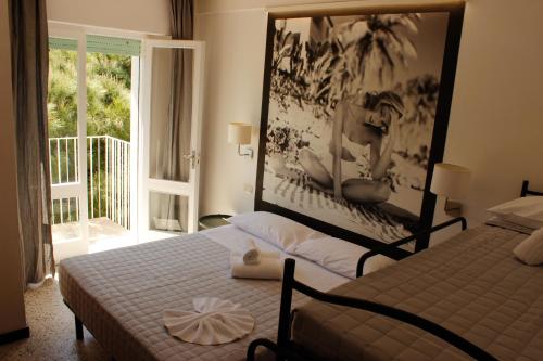 a bedroom with two beds and a large window at Hotel Hollywood Convenzionato Aquafan in Riccione