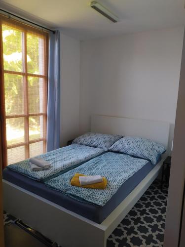 a bedroom with a bed with a blue comforter and a window at VILA CALLUM - výhodné dlouhodobé pronájmy v RD in Ostrava