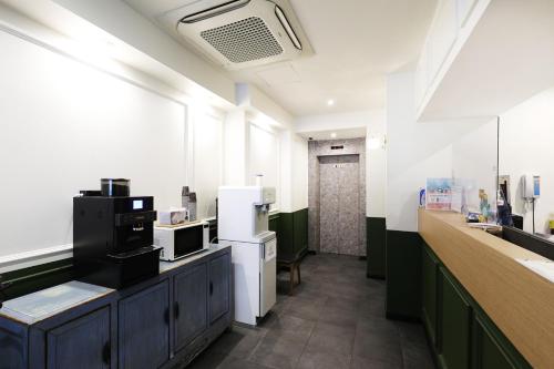 a kitchen with a counter with a refrigerator and a sink at Selene Hotel in Seoul