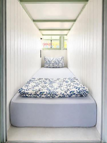 a bed in a small room in a house at Easy Monday Pool Capsule Hotel - Old Town Bangkok in Bangkok