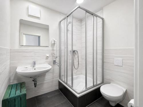 ein Badezimmer mit Dusche, Toilette und Waschbecken in der Unterkunft Elbhotel Dresden by AURUM in Dresden
