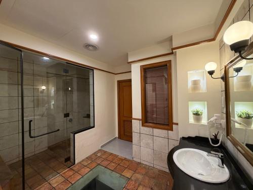 a bathroom with a shower and a toilet and a sink at Brassalova Signature Stay in Port Dickson