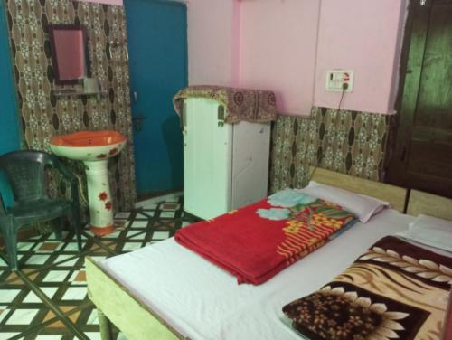 a room with a bed and a sink in a room at Hotel shiva in Sar