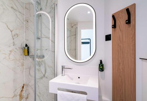 a bathroom with a sink and a mirror at B&B HOTEL Bayeux in Bayeux