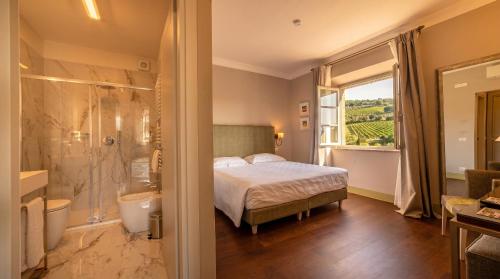 a bedroom with a bed and a bathroom with a shower at Ultimo Mulino Country Hotel in Gaiole in Chianti