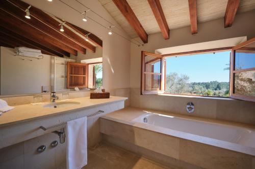 a bathroom with a tub and a sink and a window at Belle Son Mas Luxury Finca Hotel in Porto Cristo