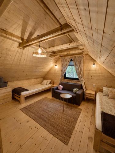 a room with a bed and a couch in a room at Domek z jacuzzi Wypoczynek Pod Lipami in Wólka