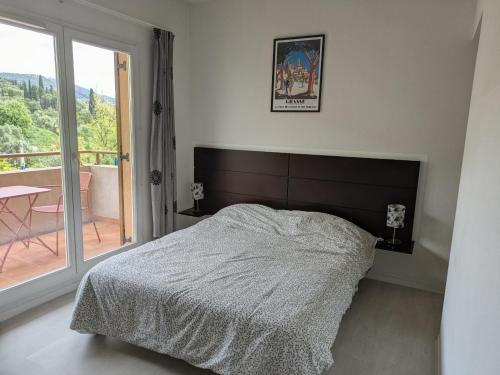a bedroom with a large bed and a balcony at Virginia N101 ST2 in Grasse