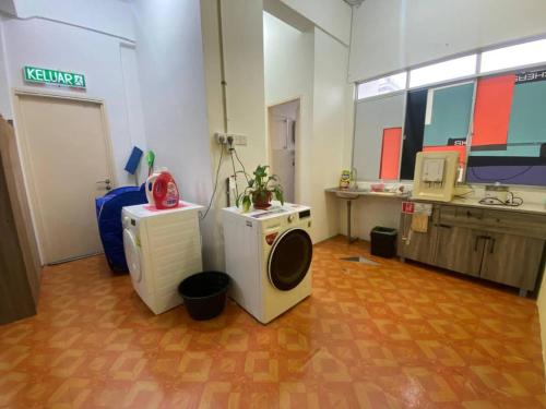 a room with a washing machine and a desk at WAQI Homestay in Miri