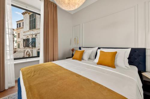 a bedroom with a large bed with a large window at King Richards Royal Residence in Dubrovnik