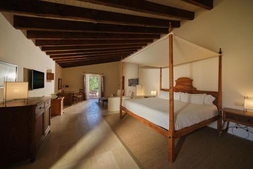 a bedroom with a canopy bed and a living room at Belle Son Mas Luxury Finca Hotel in Porto Cristo