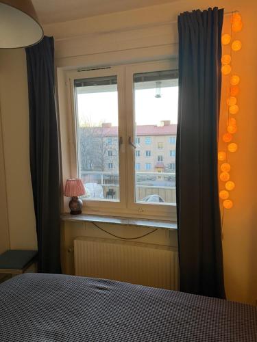 a bedroom with a window with a view of a city at PRIVATE ROOM in a shared apartment in Västerås