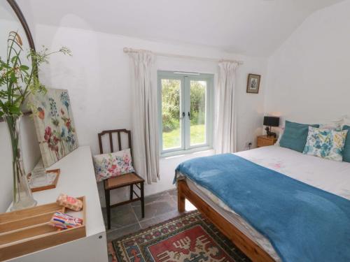 a bedroom with a bed and a window at Rhos Y Clegyrn in Goodwick