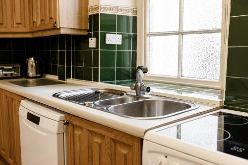 a kitchen with a sink and a window at Cheviot Manor in Wooler